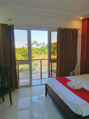 ein Schlafzimmer mit einem Bett und einem großen Fenster in der Unterkunft Royale Parc Hotel Puerto Princesa Palawan in Puerto Princesa