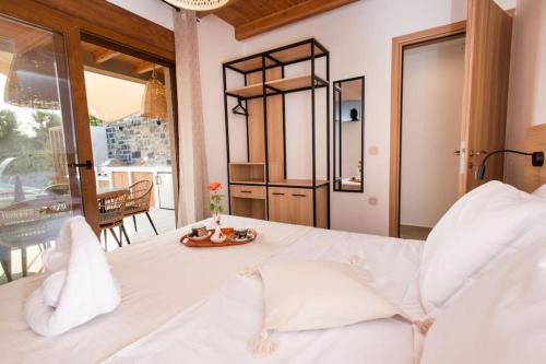 Un dormitorio con una cama blanca con una bandeja de comida. en Sweet memories in amazing Villa Eualia w pool en Anópolis