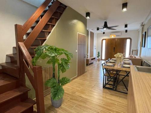 a living room with a staircase and a table with a plant at Private house with Pagoda view, near Grand Palace in Bangkok
