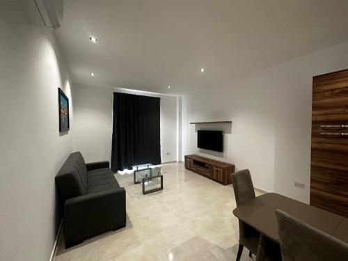 sala de estar con sofá y TV en Smart 1 Bedroom Apartment in Noah Apartments, Gzira, en Il-Gżira