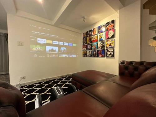 Cozy home @ Chatcuchak/中文服务 في Bang O: غرفة معيشة بها كنب جلدي وشاشة كبيرة