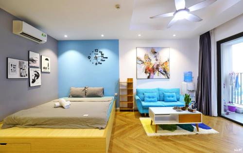 Harmony Vinhomes D'Capitale في هانوي: غرفة نوم بسرير واريكة زرقاء