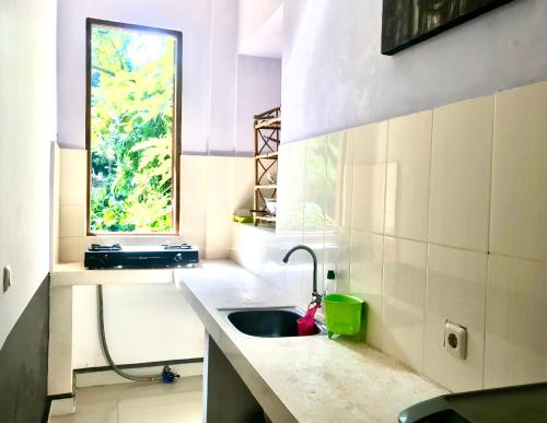 a kitchen with a sink and a window at Suastika Guest House in Ubud