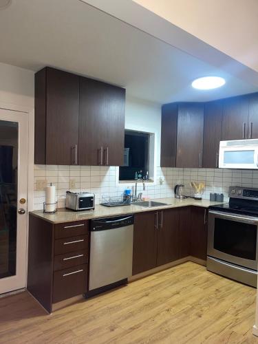 an empty kitchen with wooden cabinets and appliances at Home in West Vancouver in West Vancouver