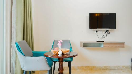 a room with two chairs and a table and a tv at Hotel Maenamla Namchi - yagi group in Namchi