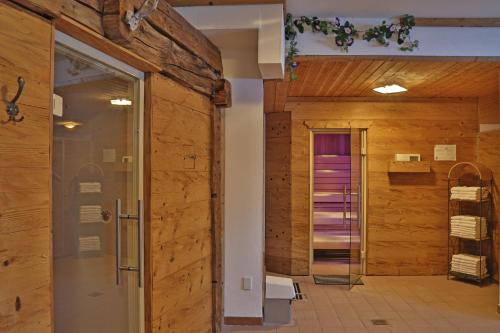 フラッハウにあるAparthotel Paradiesの木製の壁とガラスドア付きのバスルーム