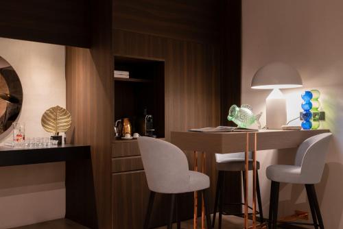 a kitchen with a table and two chairs and a table with a lamp at Agra Suites in Naples