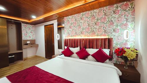 1 dormitorio con 1 cama blanca grande con almohadas rojas en Sumi Stays, en Bijanbāri Bāzār
