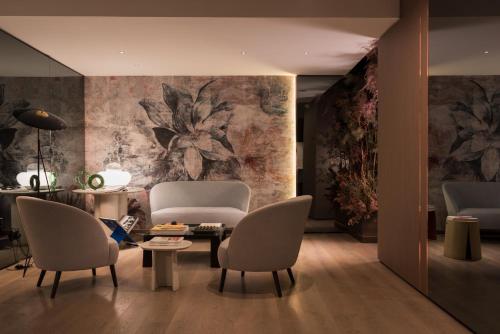 a living room with two chairs and a table at Agra Suites in Naples