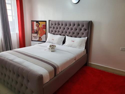 a bedroom with a large bed with a large headboard at macdade apartment in Nairobi