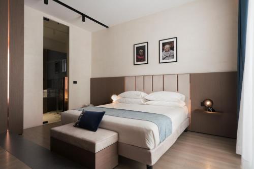 a bedroom with a large bed and a chair at Agra Suites in Naples