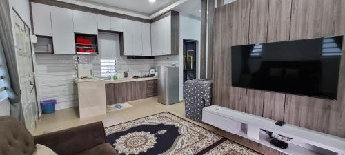 a living room with a flat screen tv on a wall at Tambun Hillview Cottage in Tambun