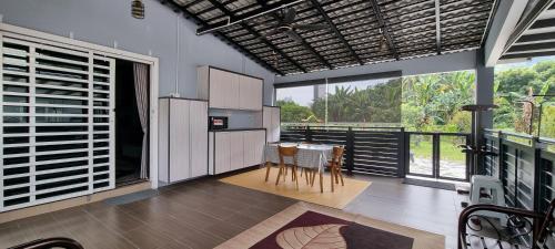 a kitchen with a table and chairs and large windows at Tambun Hillview Cottage in Tambun