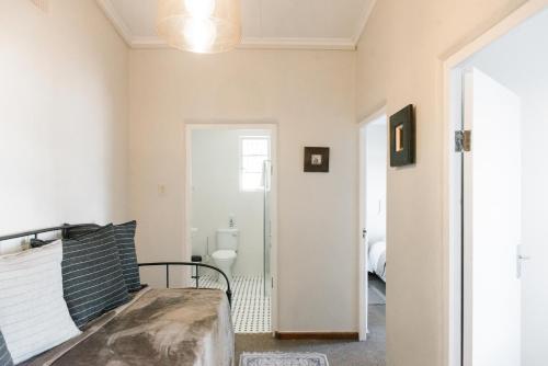 a living room with a bed and a bathroom at Kokerboom House in Vanrhynsdorp