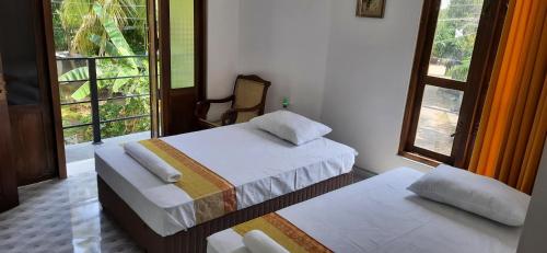 a bedroom with two beds and a window at Thambara Resort in Polonnaruwa