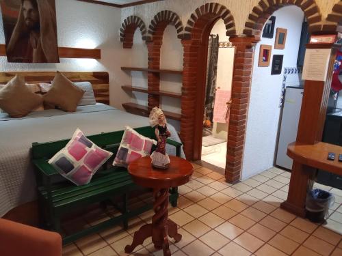 チョルーラにあるVilla Cholulaの部屋にベッドとテーブルがある寝室