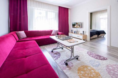 a living room with a pink couch and a table at seyir royal in Kayseri