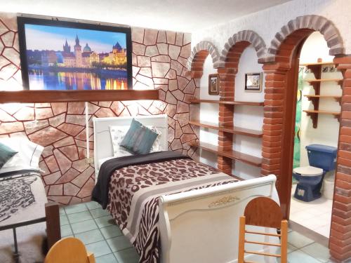 a bedroom with a bed and a tv on a wall at Villa Cholula in Cholula
