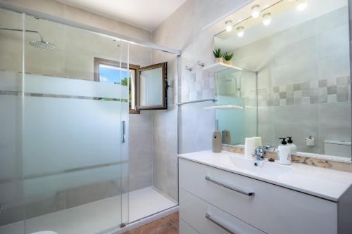 a bathroom with a shower and a sink and a mirror at Casa Jordi in Can Picafort
