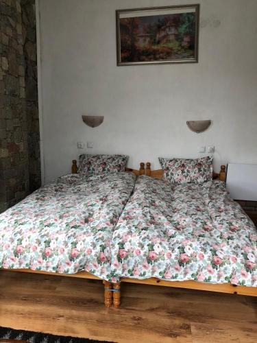 a bedroom with a bed with a floral comforter at Лилянината къща in Kalofer