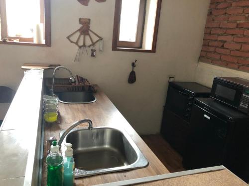 a kitchen with a sink and a microwave at Лилянината къща in Kalofer