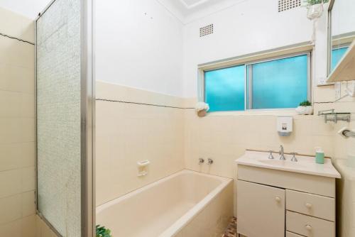 a bathroom with a tub and a sink at Private Room in Sans Souci Guesthouse - Sharehouse RM 3 in Sydney