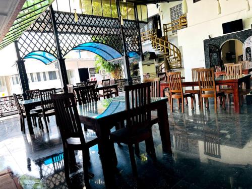 a dining room with tables and chairs in a restaurant at Grand Crown Hotel in Anuradhapura