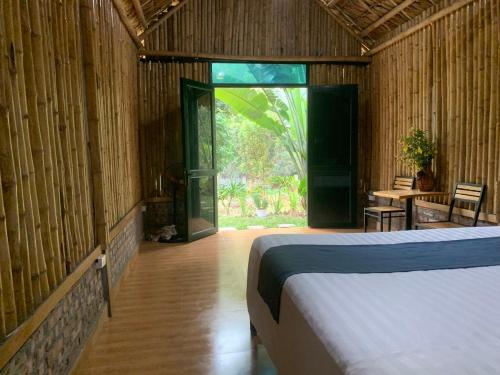 a bedroom with a bed and a table in a room at Cat Ba Island Garden Homestay - Papillon in Cat Ba