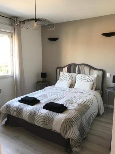 1 dormitorio con 1 cama grande y 2 toallas negras. en Maison 6 chambres, en Beauvais