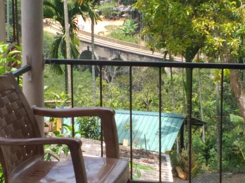 a balcony with a chair and a view of a pool at Nine Arch Araliya Homestay in Ella