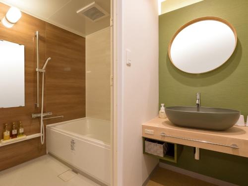 a bathroom with a sink and a tub and a mirror at Tokai City Hotel - Vacation STAY 83890v in Tokai