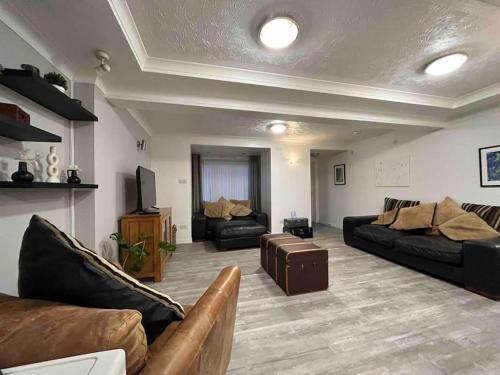 a living room with two couches and a tv at Gwalia stores in Aberporth