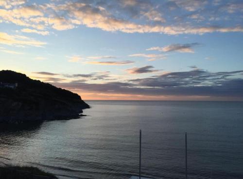 a view of a body of water with a sunset at Gwalia stores in Aberporth