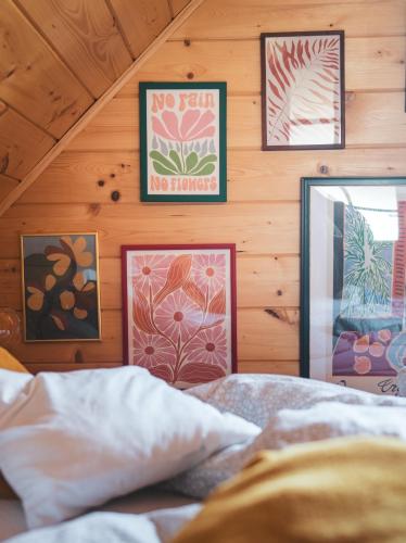 a bedroom with wood paneling and pictures on the wall at Leśna 21 Dom Południe przy PUSZCZA BIAŁOWIESKA in Łuka