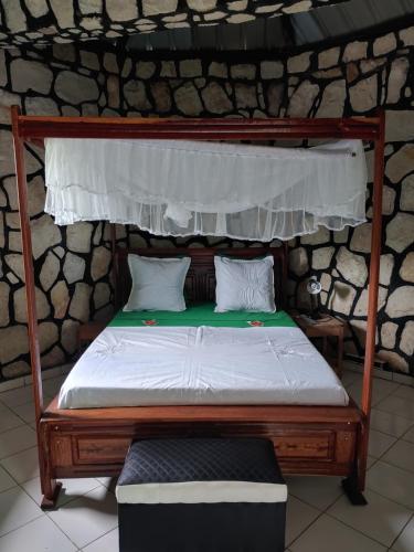 a bed with a wooden frame and a white mattress at Châteaux Yolande in Mahajanga
