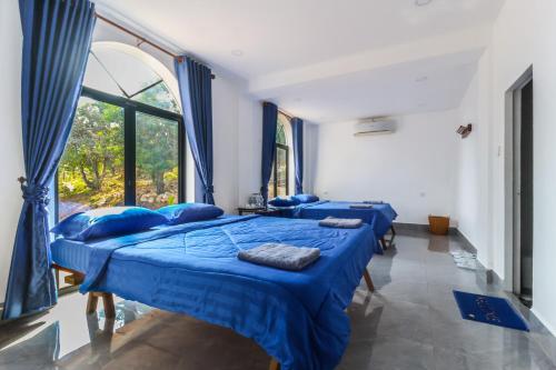 three beds in a room with a window at Kampot Hill Lodge in Kampot