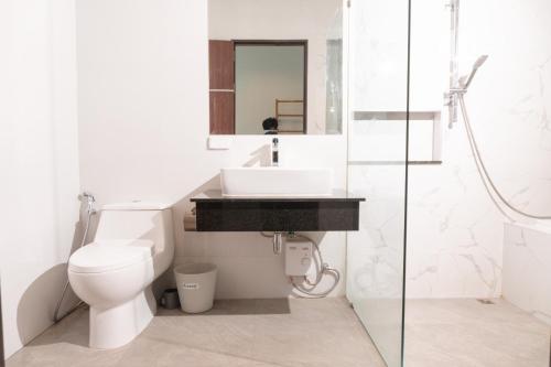 a white bathroom with a sink and a toilet at Temmy Pool Villa, Chaam - Hua Hin in Phetchaburi