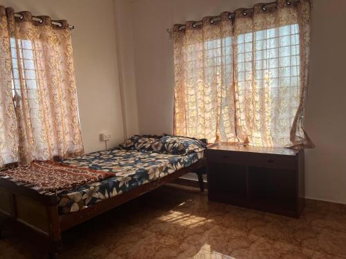 1 dormitorio con 1 cama y 2 ventanas grandes en One room with kitchen, WiFi and washing machine, en Bangalore