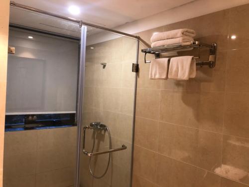 baño con ducha y puerta de cristal en Ivory Villas Hòa Bình, en Hòa Bình