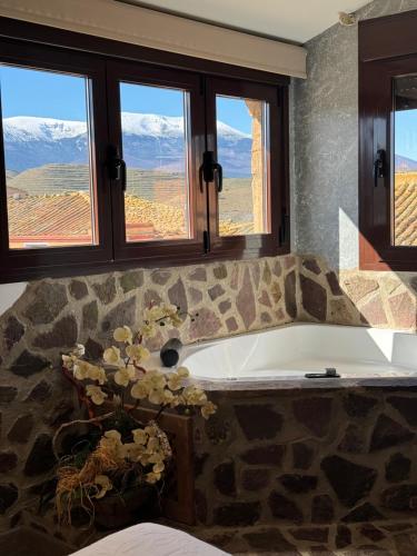 a bathroom with a large bath tub with windows at El Rincon del Moncayo in Vera de Moncayo
