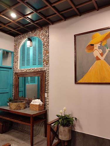 a painting of a woman in a yellow dress on a wall at THE NAM DU HILL resort in Nam Du