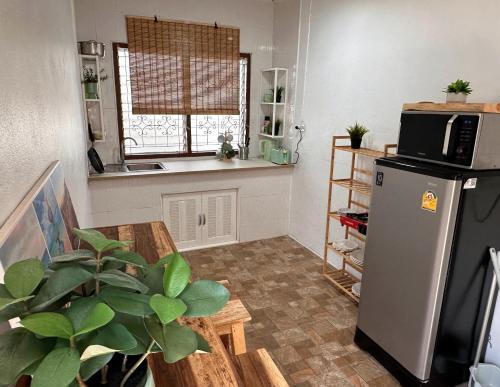 a kitchen with a refrigerator and a table with a plant at Bamboo Beach House @ Phang Nga in Thai Muang