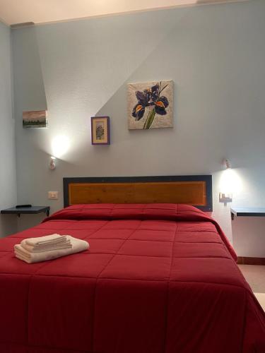 a bedroom with a red bed with a red blanket at Lattrazionedelgeco in Terni