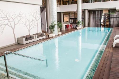 a large swimming pool in a hotel lobby at Urban Studio Pvt Appartment in Durban