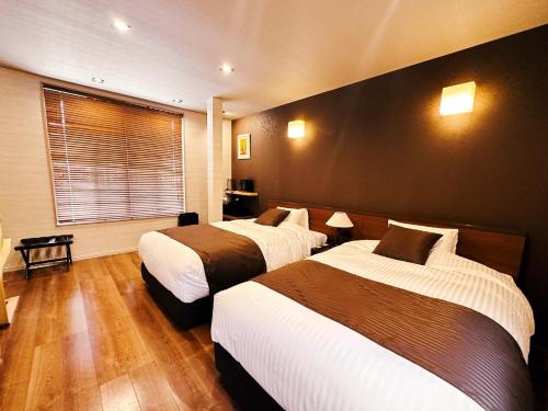 een hotelkamer met 2 bedden en een raam bij Setouchi Hitotsuru HITOTSURU - Vacation STAY 13561v in Onomichi