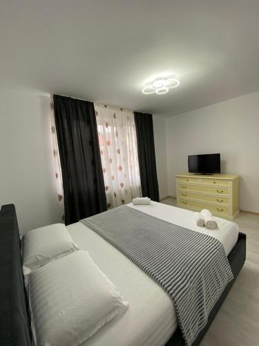 a bedroom with two beds and a dresser at SorinaApartament in Tîrgu Neamţ