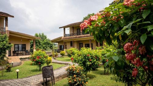 a garden in front of a house with flowers at Wild Adventure Resort in Sauraha