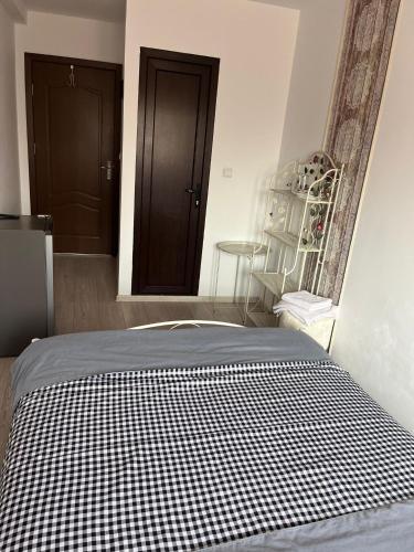 a bed with a black and white checkered blanket at Solaria Budget Studio in Galaţi