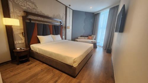 une chambre d'hôtel avec un lit et une chaise dans l'établissement APEC MANDALA KOLYA Building D, à Phan Thiết