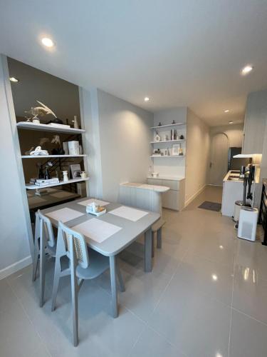 a dining room with a white table and chairs at New Townhouse @Central Rayong in Rayong